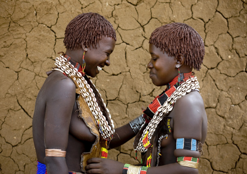 Portrait Of Two Laughing Hamar Tribe Women Posing With Traditional Necklace And Animal Skin-made Clothes, Turmi, Omo Valley, Ethiopia