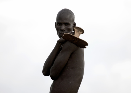 Portrait Of A Dassanech Man Holding His Headrest, Omo Valley, Kangate, Ethiopia
