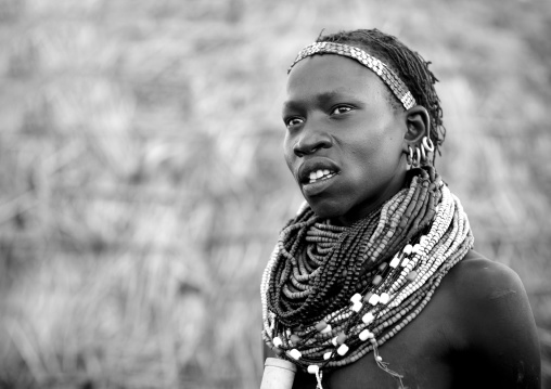 Portrait Of A Young Nyangatom Tribe Woman Wearing Some Big Beaded Necklaces, Omo Valley, Ethiopia