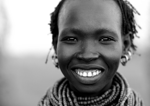 Black And White Portrait Of A Young Nyangatom Tribe Woman With Toothy Smile, Omo Valley, Kangate, Ethiopia