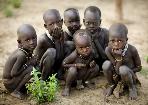 Group Of Karo Tribe Kids Squatting And Looking Shyly At The Camera, Korcho Village, Ethiopia