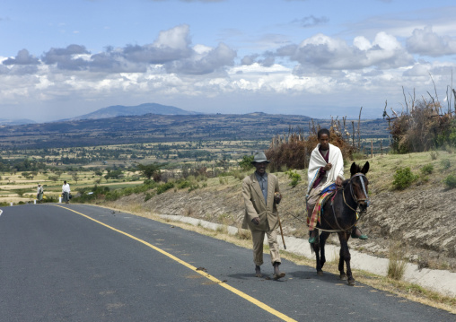 Man riding a horse on a brand new highway, Konso, Ethiopia