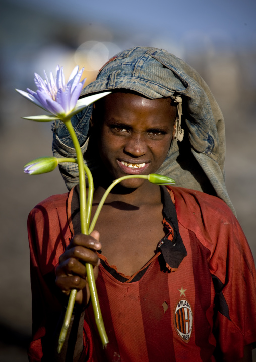 Portrait Of A Boy From Oromo Tribe Holding A Water Lily, Chamo Lake, Ethiopia