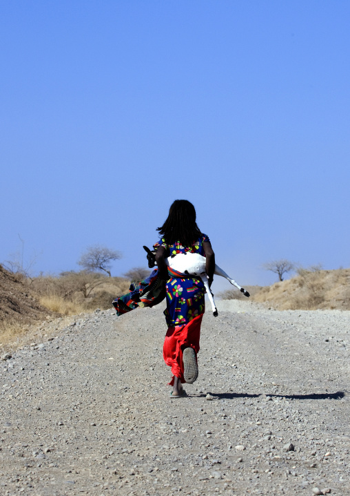 Afar girl carrying a goat, Assaita, Afar regional state, Ethiopia