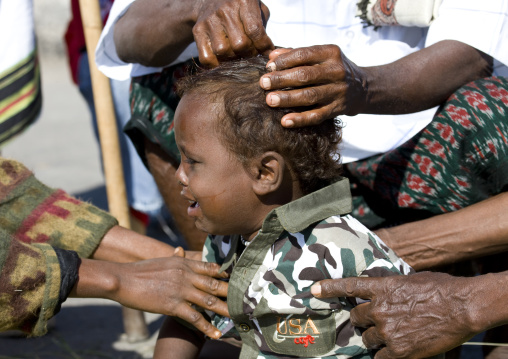 Baby having hair shaved at aid el kebir celebration, Assaita, Afar regional state, Ethiopia