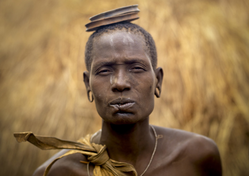 Mursi Woman Whose Inferior Lip Was Cut Carrying Two Clay Lip Plates On His Head Ethiopia