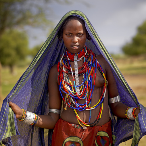 Young Erbore Girl With Beaded Necklaces Posing Under Large Canvas Ethiopia
