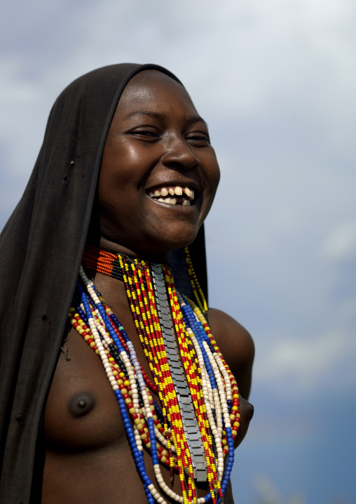 Portrait Of An Erbore Tribe Woman With Toothy Smile, Black Veil And Colourful Necklaces, Weito, Omo Valley, Ethiopia