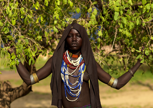 Portrait Of An Erbore Tribe Woman With Black Veil And Colourful Necklaces Posing Under A Tree, Weito, Omo Valley, Ethiopia