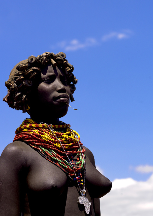 Portrait Of A Proud Dassanech Tribe Girl With Wig Made Of Caps And Colourful Necklaces, Omorate, Omo Valley, Ethiopia