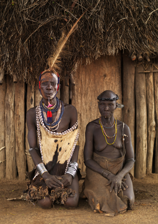 Portrait Of A Karo Tribe Couple In Traditional Clothes Posing Outside Their House, Korcho Village, Omo Valley, Ethiopia