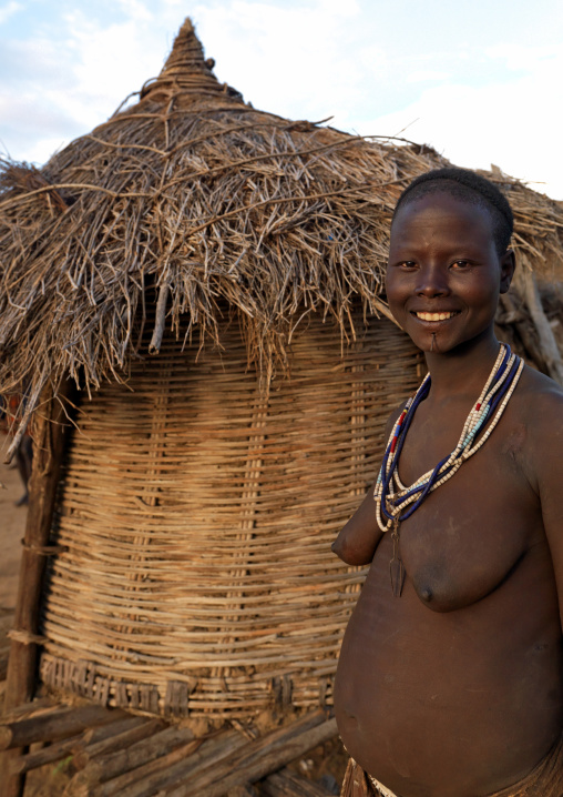 Portrait Of A Karo Tribe Woman With Toothy Smile Posing Outside Her Hut, Korcho Village, Omo Valley, Ethiopia
