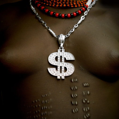 Close-up On The Chest Of A Bodi Tribe Woman With Dollar Shaped Silver Pendant And Scarifications, Hana Mursi, Omo Valley, Ethiopia