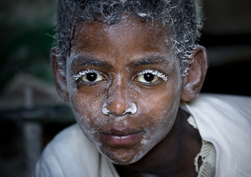 Boy working in a mill with flour on his face, Bati, Amhara region, Ethiopia