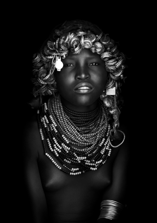 Black And White Portrait Of A Dassanech Tribe Girl With Wig Made Of Caps And Traditional Necklaces, Omorate, Omo Valley, Ethiopia