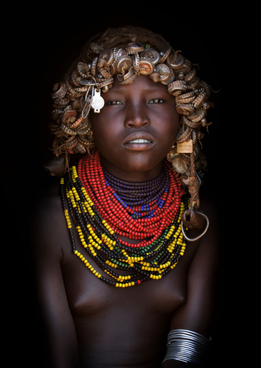 Portrait Of A Dassanech Tribe Girl With Wig Made Of Caps And Traditional Necklaces, Omorate, Omo Valley, Ethiopia