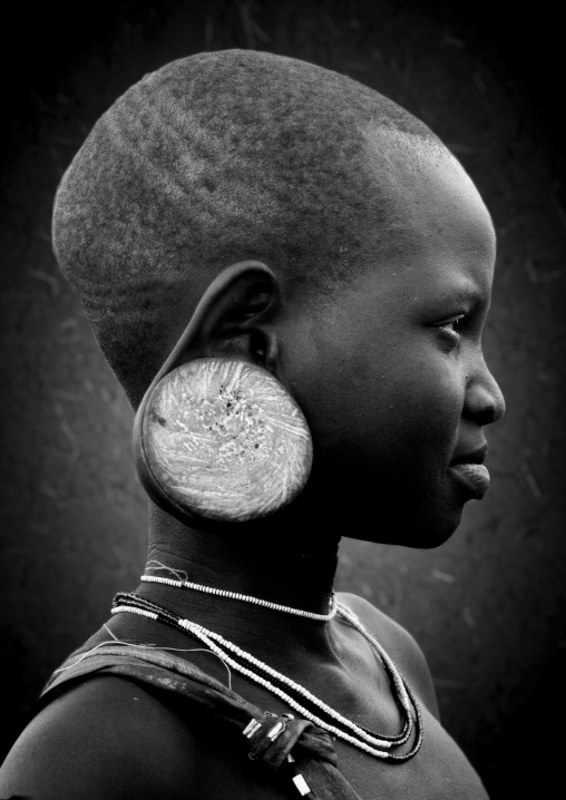 Black And White Profile Portrait Of A Mursi Tribe Young Girl With Enlarged Ear, With Ear Plate, Omo Valley, Ethiopia