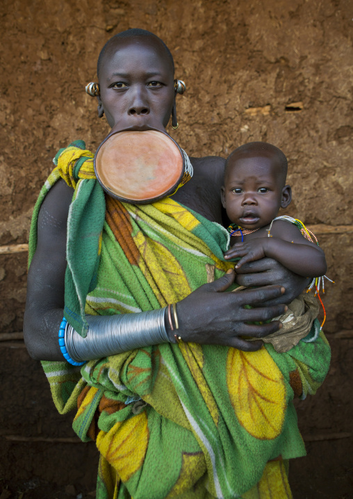 Suri tribe woman with a lip plate and her baby, Kibish, Omo valley, Ethiopia