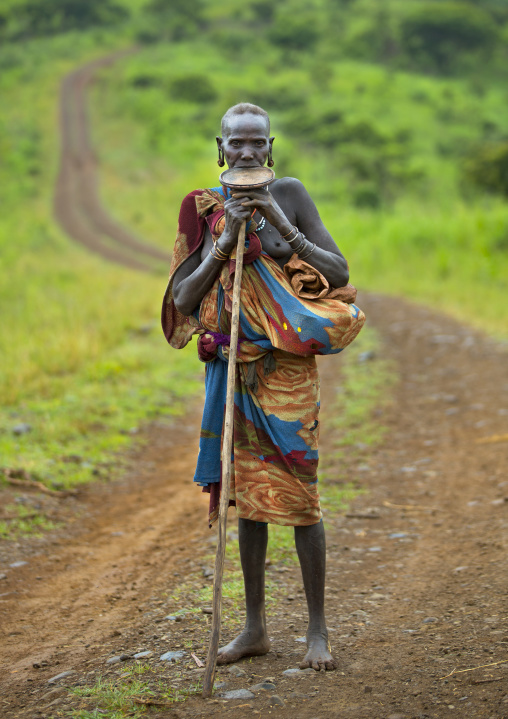 Portrait of a Suri tribe woman with a lip plate on a road, Kibish, Omo valley, Ethiopia