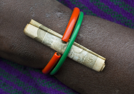 Detail of a bracelet with a birr note on a Suri tribe woman, Kibish, Omo valley, Ethiopia