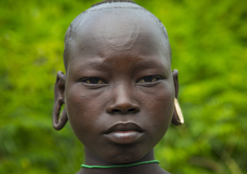 Portrait of a Suri tribe girl with enlarged earlobes, Tulgit, Omo valley, Ethiopia