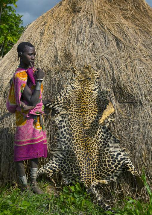 Suri woman posing near an animal skin, Tulgit, Omo valley, Ethiopia