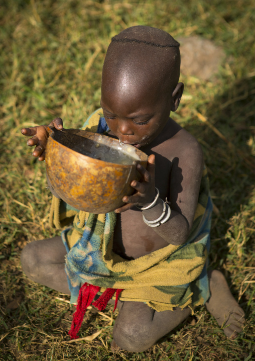 Suri child drinking milk, Tulgit, Omo valley, Ethiopia