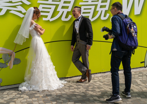 Bride and groom with a photographer, Kowloon, Hong Kong, China