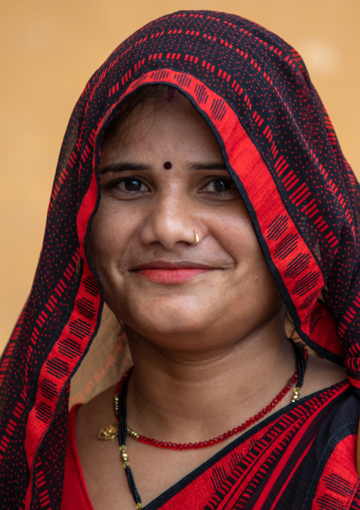 Portrait of a smiling rajasthani woman in traditional red sari, Rajasthan, Amer, India