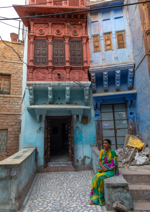 Indian woman in front of an old blue house of a brahmin, Rajasthan, Jodhpur, India