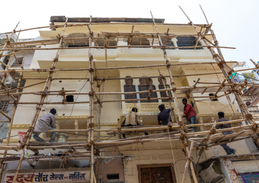 Indian workers on scaffoldings renovating the city palace, Rajasthan, Udaipur, India