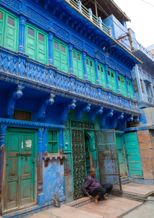 Indian man in front of an old blue house of a brahmin, Rajasthan, Jodhpur, India