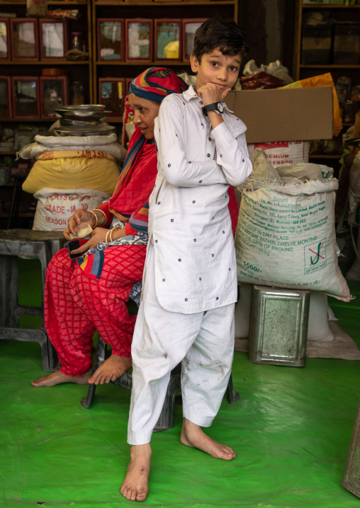 Young indian boy in white clothes posing for the picture in a shop, Rajasthan, Jodhpur, India