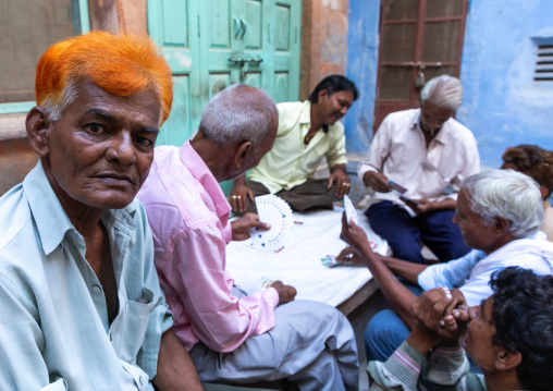 Portrait of a man with ginger hair with friends playing cards, Rajasthan, Jodhpur, India