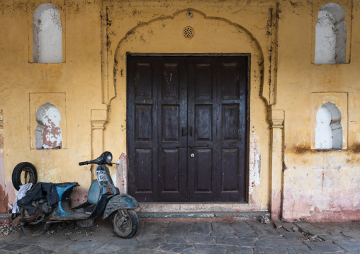 Old scooter parked in front of a wooden door, Rajasthan, Jaipur, India
