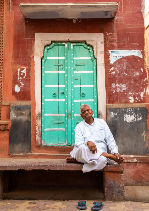 Indian man standing in front of a beautiful door of a haveli in the old city, Rajasthan, Bikaner, India