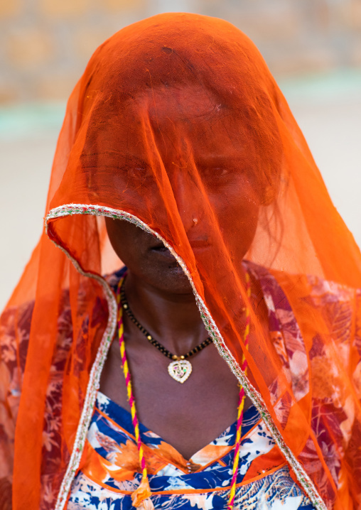 Portrait of a rajasthani woman hidding her face under an orange sari, Rajasthan, Jaisalmer, India
