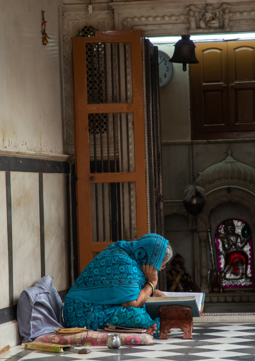 Indian woman reading a book in an old house, Rajasthan, Bikaner, India