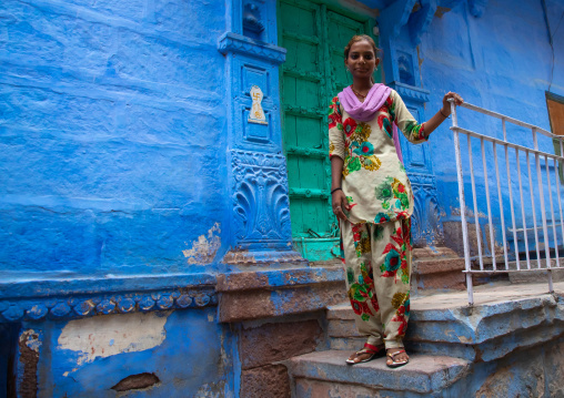 Portrait of a rajasthani teenage girl in traditional sari in front of a blue house, Rajasthan, Jodhpur, India