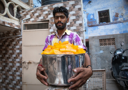 Indian man carrying food in the street, Rajasthan, Jodhpur, India