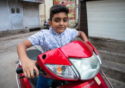 Portrait of a rajasthani boy riding a scooter, Rajasthan, Jodhpur, India