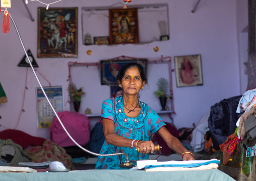 Portrait of a rajasthani woman ironing, Rajasthan, Bundi, India