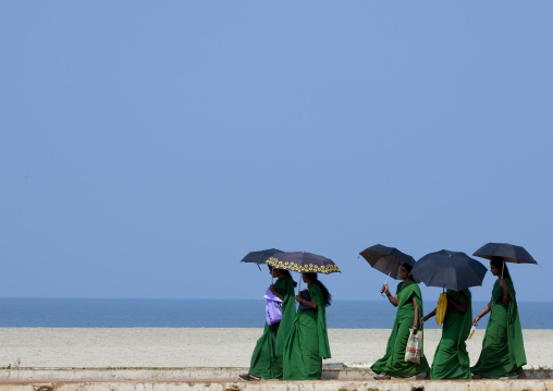 Group Of Young Women In Green Sari Holding Umbrellas Walking Down Alleppey Beach, India