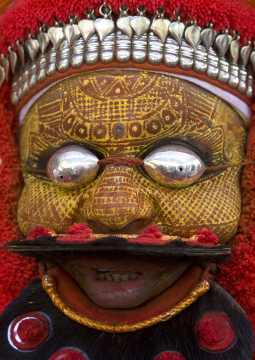 Man Dressed For Theyyam Ceremony With Traditional Painting On His Face And A Mask On His Eyes, Thalassery, India