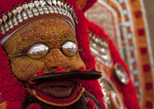 Man Dressed For Theyyam Ceremony With Traditional Painting On His Face And A Mask On His Eyes, Thalassery, India