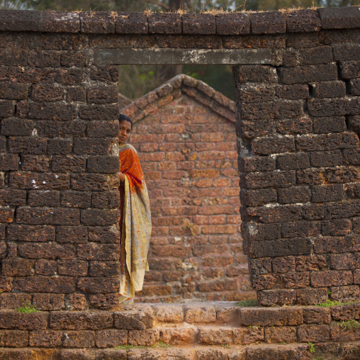 Woman In Sari Hiding Behind A Wall At Thalassery Fort, India