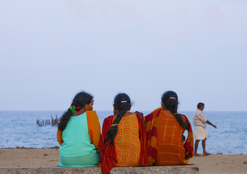 Rear View Of Three Women Sitting On A Bank At Pondicherry Seaside, India