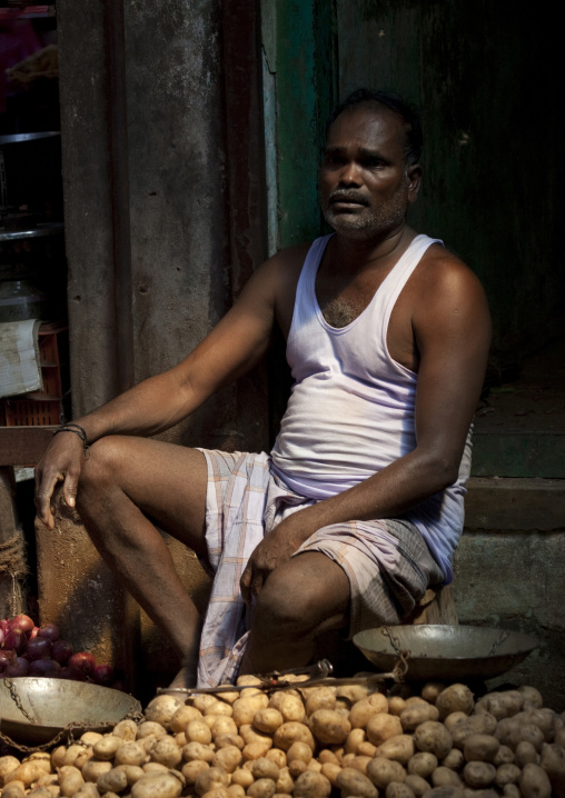 Sellers Sitting Behind His Stalls Of Potatoes And Onions At Pondicherry Market, India