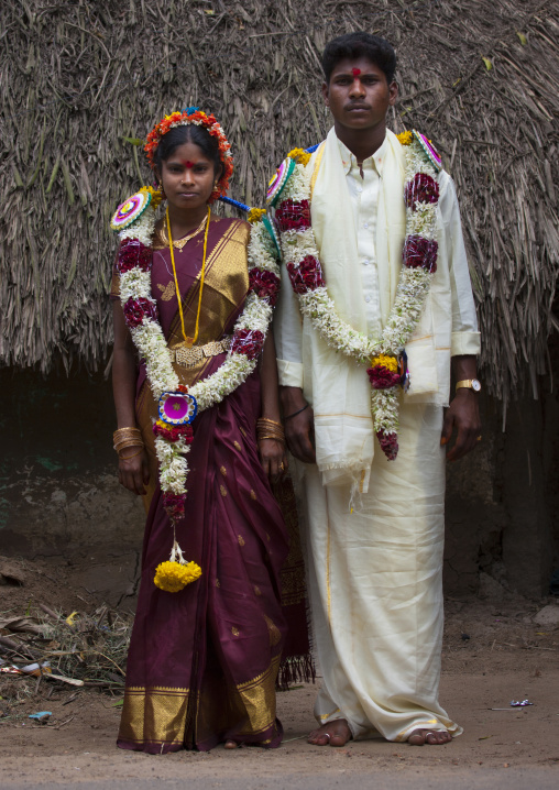 Young Bride And Groom Standing In Front Of A House Dressed For The Ceremony And Adorned With Flower Garlands, Pondicherry, India