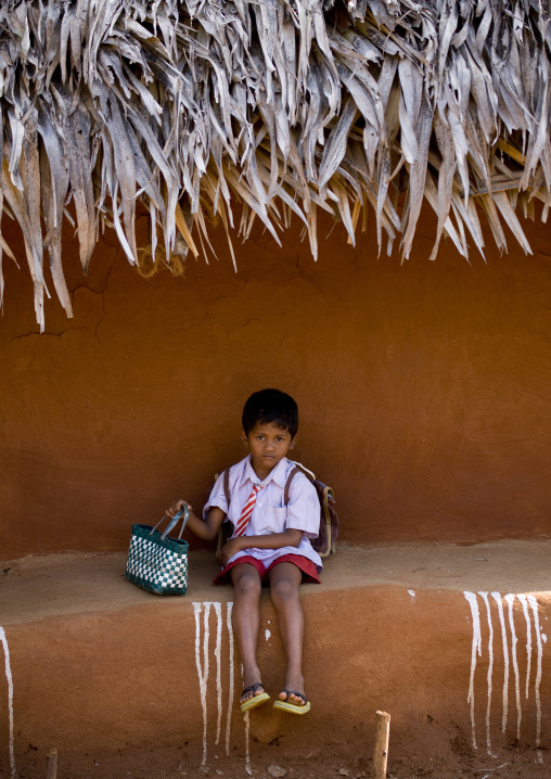 Young Boy Back From School Sitting In Front Of His Adobe House In Tamil Nadu, Madurai, India